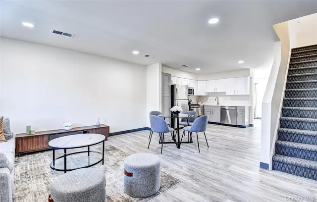 a living room with furniture a wooden floor and next to a window