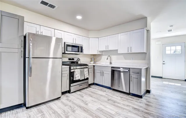 a kitchen with a refrigerator stove and wooden cabinets