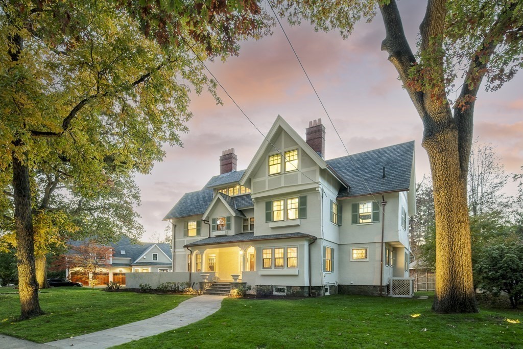 a front view of a house with a yard and trees