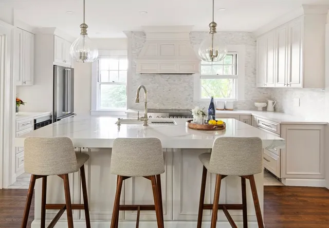 a kitchen with a dining table chairs sink and granite counter tops