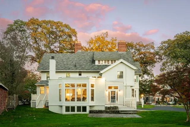 a view of a white house with a yard
