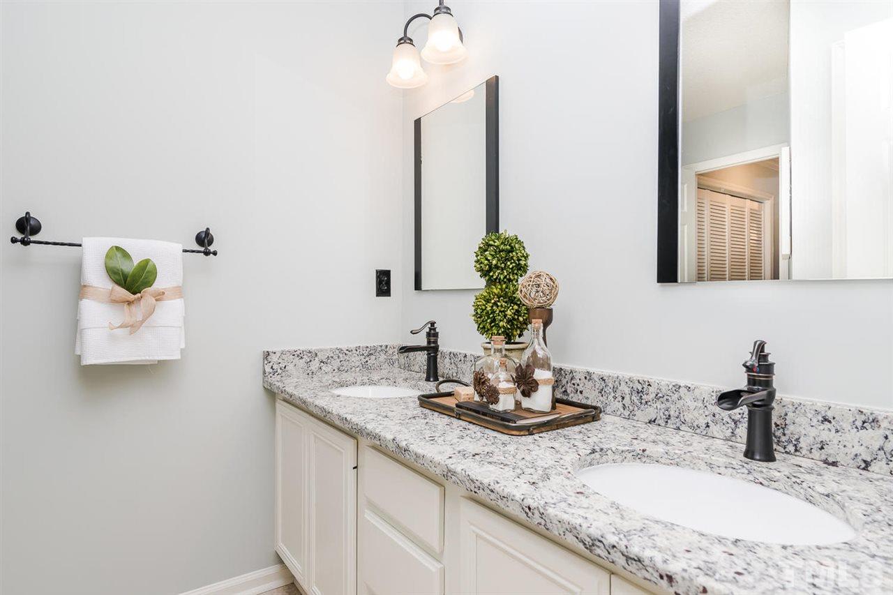 308 Crosspine Drive Raleigh, NC 27603 - Photo 8 of 11 Master bath has modern updates including new granite counters with dual vanities, new lighting and new faucets.
