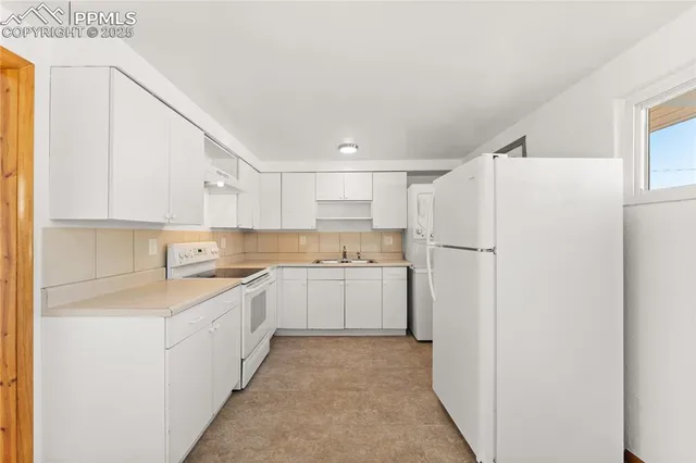 a kitchen with white cabinets and white appliances