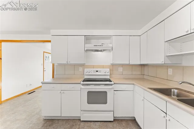 a kitchen with white cabinets and white appliances