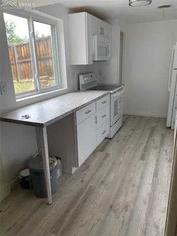 a kitchen with a sink cabinets and wooden floor