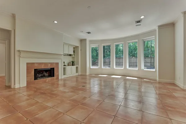 a view of an empty room with a fireplace and a window
