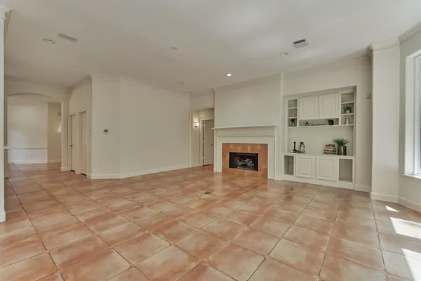 a view of empty room with cabinet and fireplace