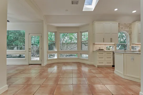 a open kitchen with cabinets and window