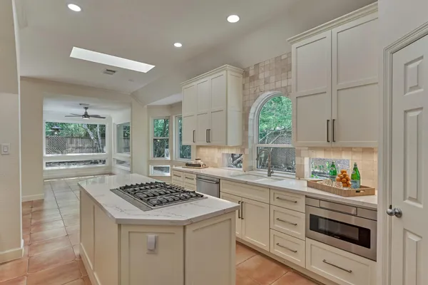 a kitchen with a stove cabinets and a window