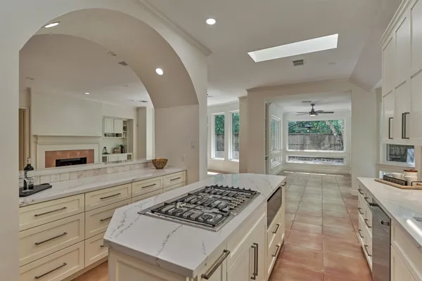 a kitchen with kitchen island white cabinets appliances and a counter top