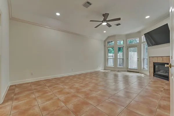 a view of an empty room with a fireplace and a window