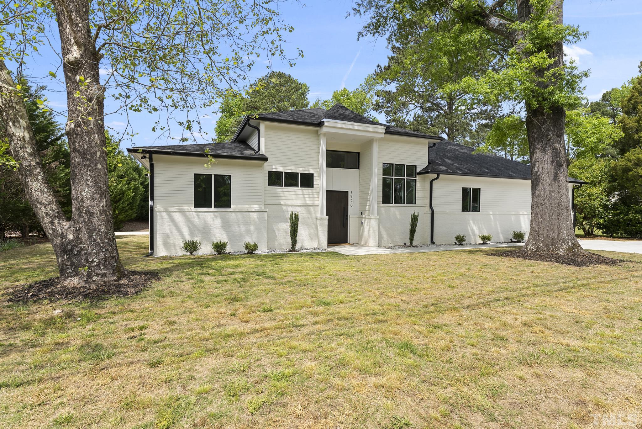 a front view of house with yard and trees