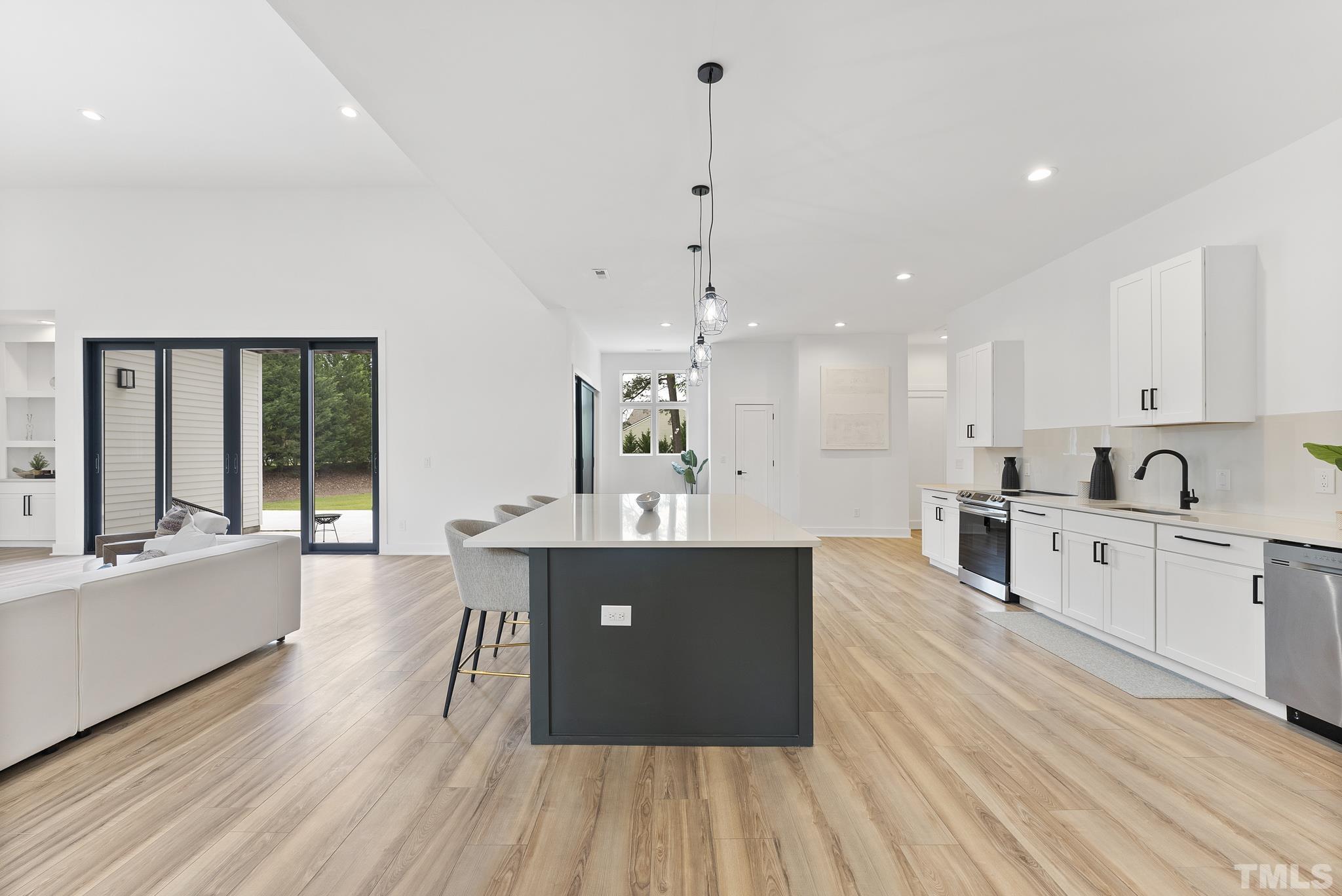 1920 Cook Road Durham, NC 27713 - Photo 11 of 43 a large kitchen with kitchen island a large counter top space a sink stainless steel appliances and cabinets