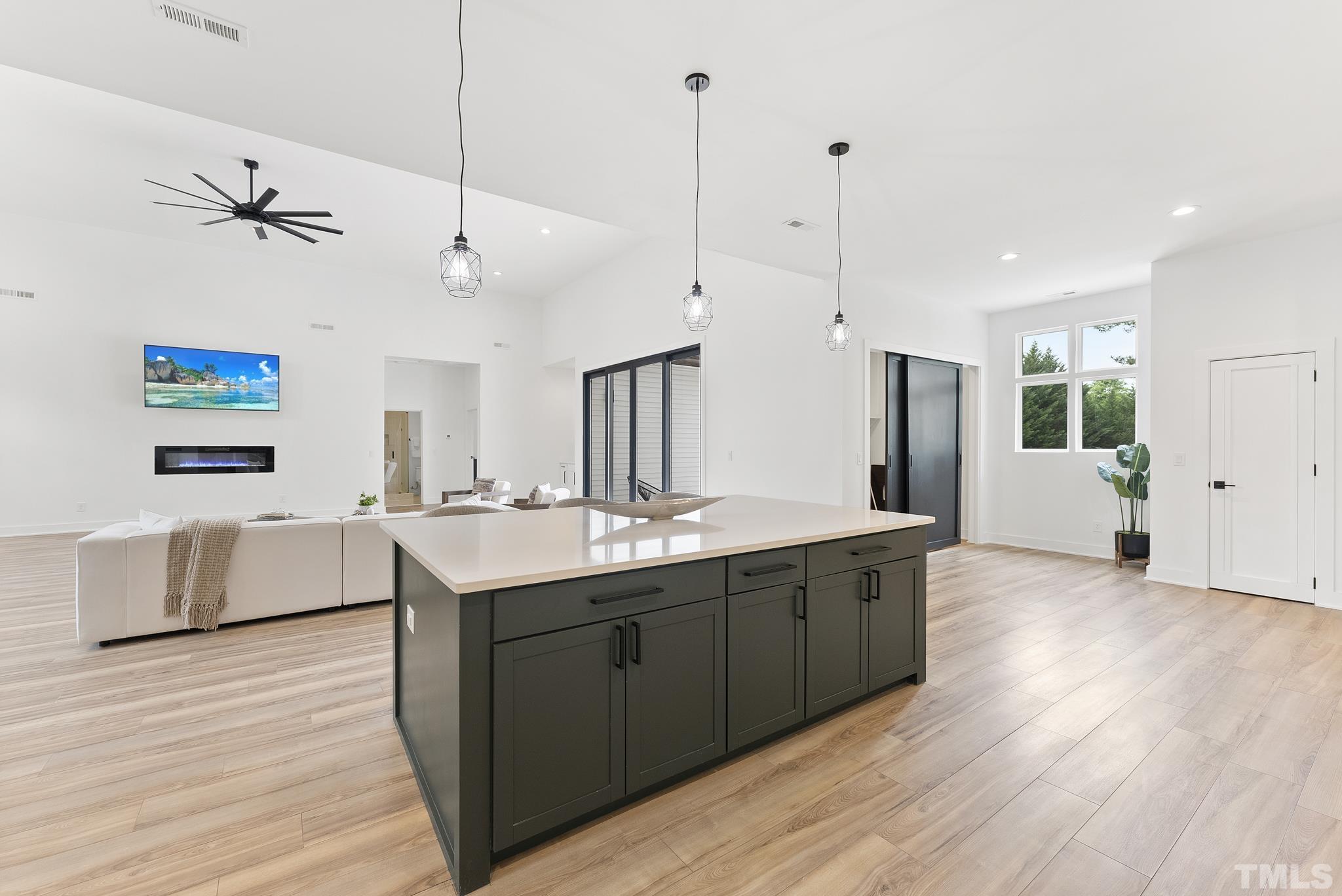 1920 Cook Road Durham, NC 27713 - Photo 12 of 43 a large kitchen with stainless steel appliances a large counter top a sink a refrigerator and a wooden floor