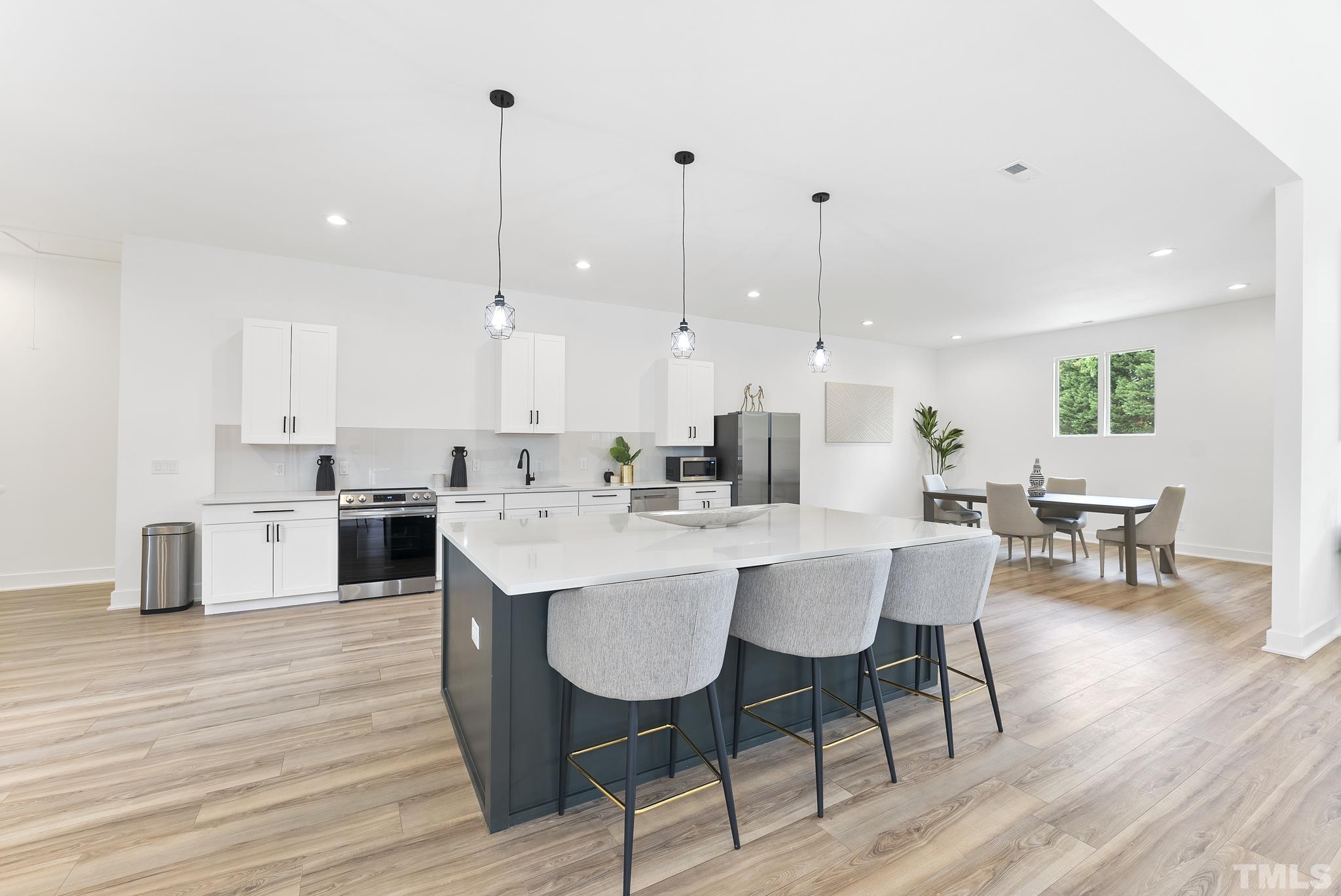 1920 Cook Road Durham, NC 27713 - Photo 6 of 43 a kitchen with stainless steel appliances kitchen island granite countertop a dining table chairs and sink
