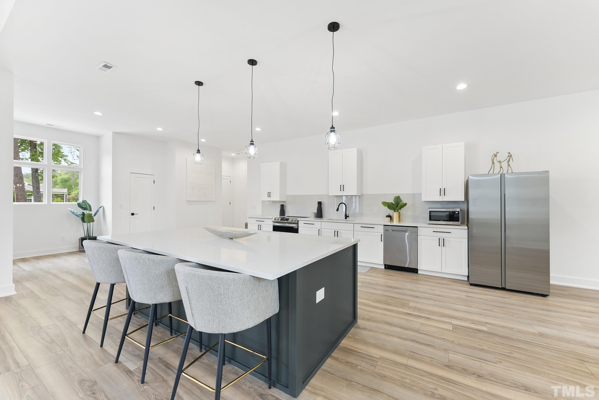 1920 Cook Road Durham, NC 27713 - Photo 8 of 43 a kitchen with stainless steel appliances granite countertop a sink a stove a refrigerator and island with wooden floor