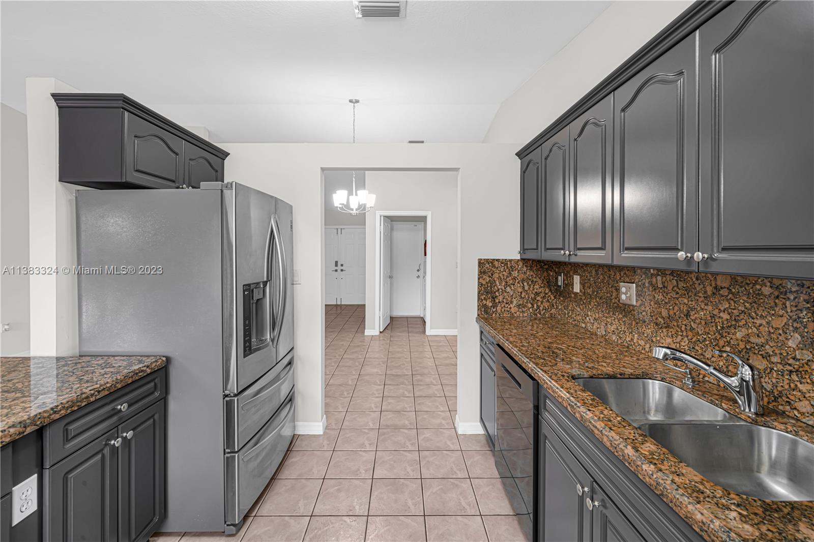 14809 Southwest 180th Street Miami, FL 33187 - Photo 14 of 38 a kitchen with granite countertop stainless steel appliances a sink stove and refrigerator