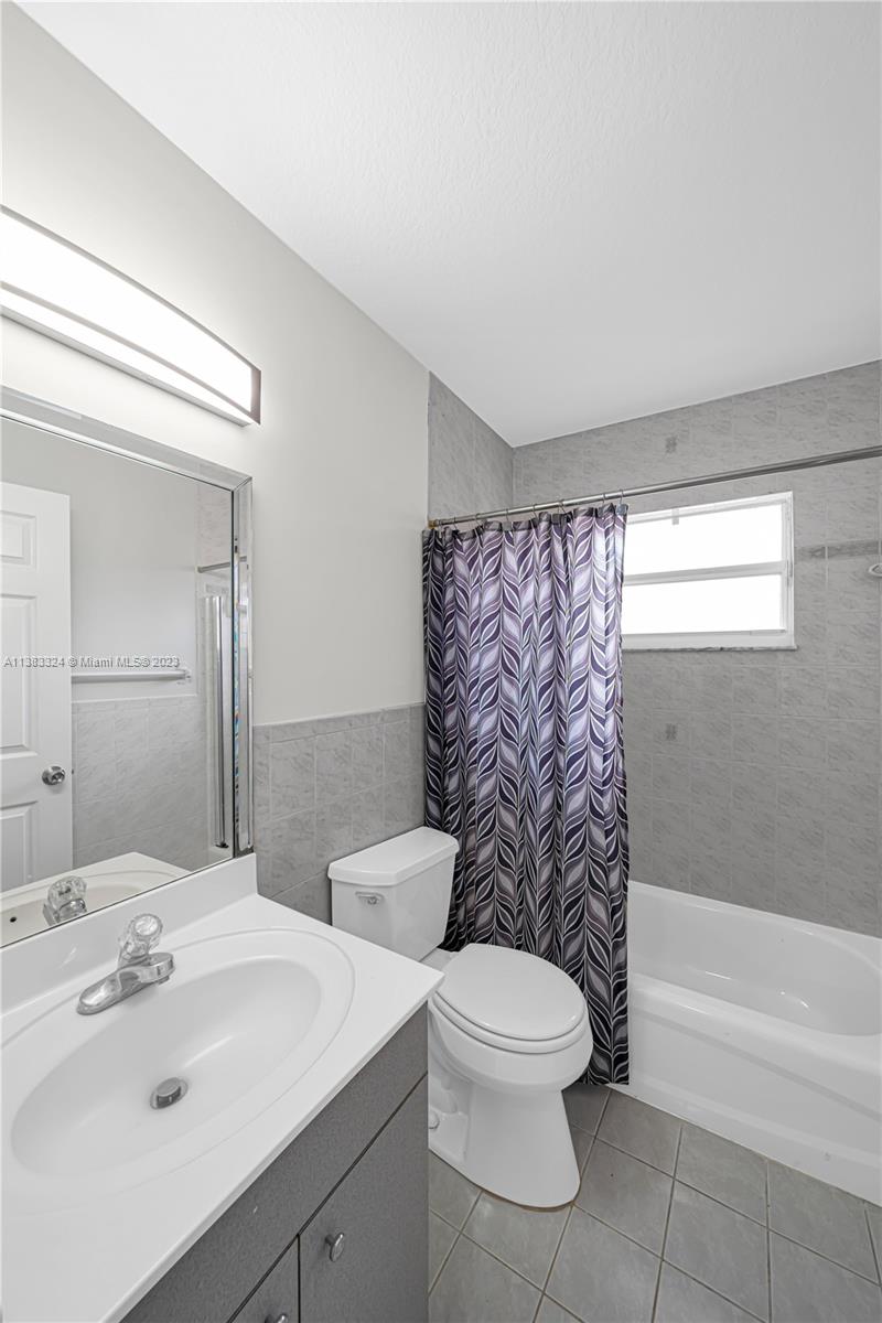 14809 Southwest 180th Street Miami, FL 33187 - Photo 20 of 38 a bathroom with a toilet a sink and bathtub