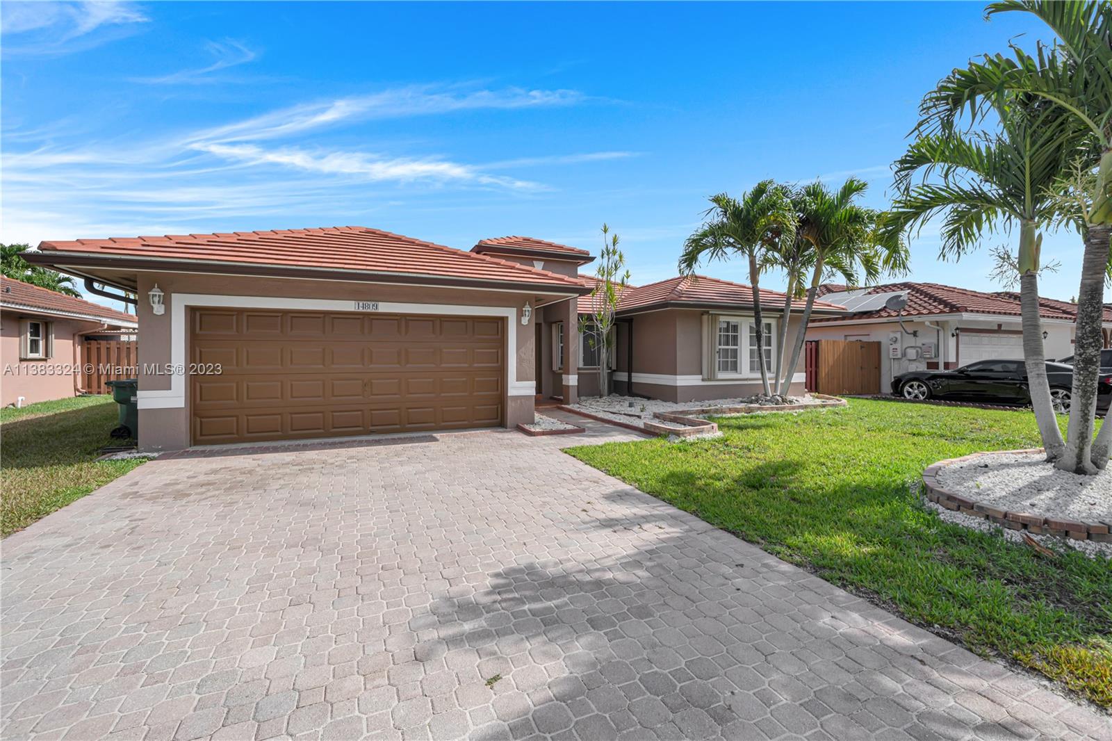 14809 Southwest 180th Street Miami, FL 33187 - Photo 2 of 38 a front view of a house with a yard and garage