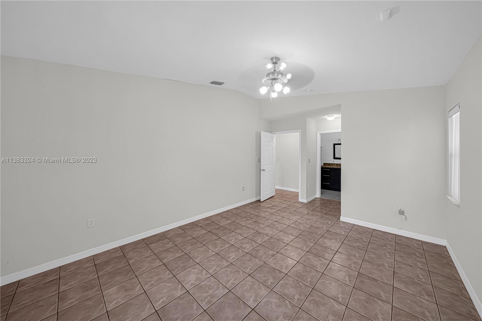 14809 Southwest 180th Street Miami, FL 33187 - Photo 28 of 38 a view of an empty room with a chandelier fan