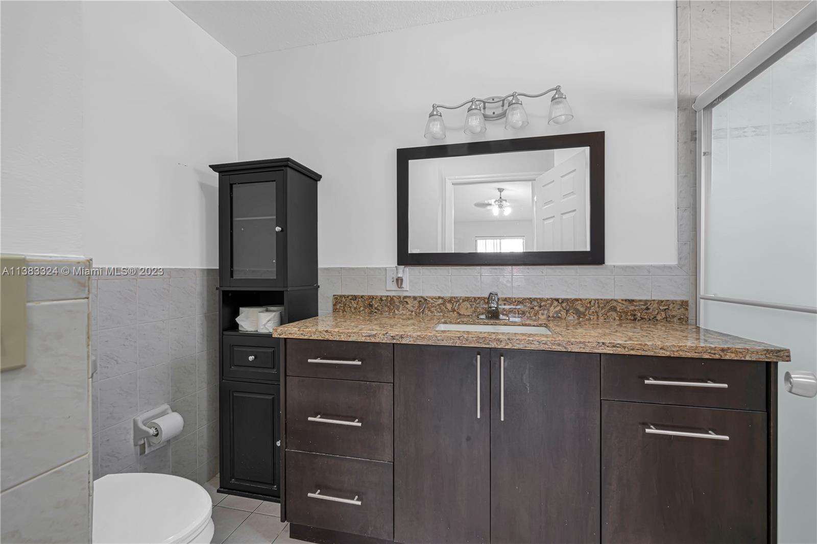 14809 Southwest 180th Street Miami, FL 33187 - Photo 29 of 38 a bathroom with a toilet sink and mirror