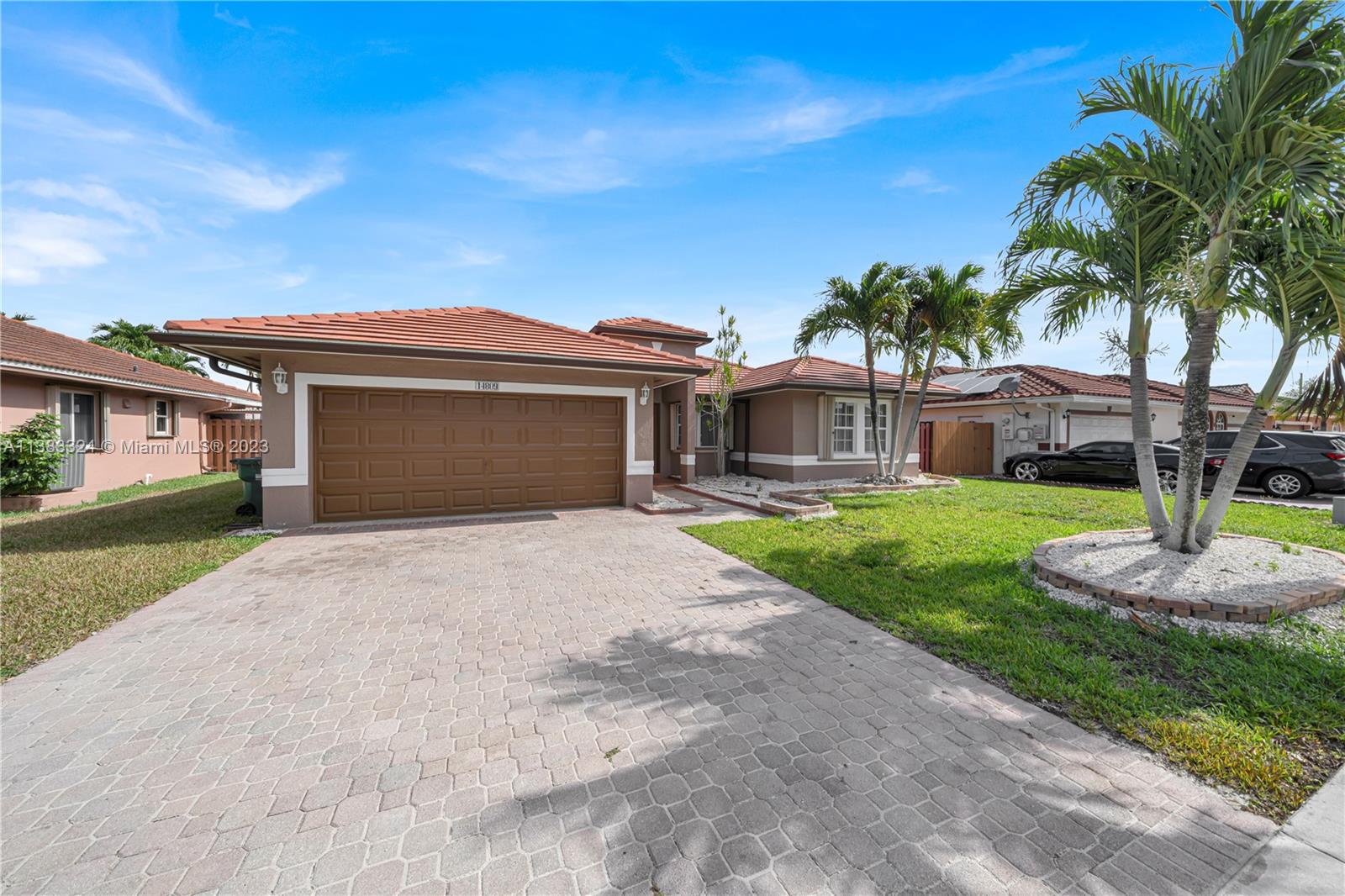 14809 Southwest 180th Street Miami, FL 33187 - Photo 3 of 38 a front view of a house with garden and trees