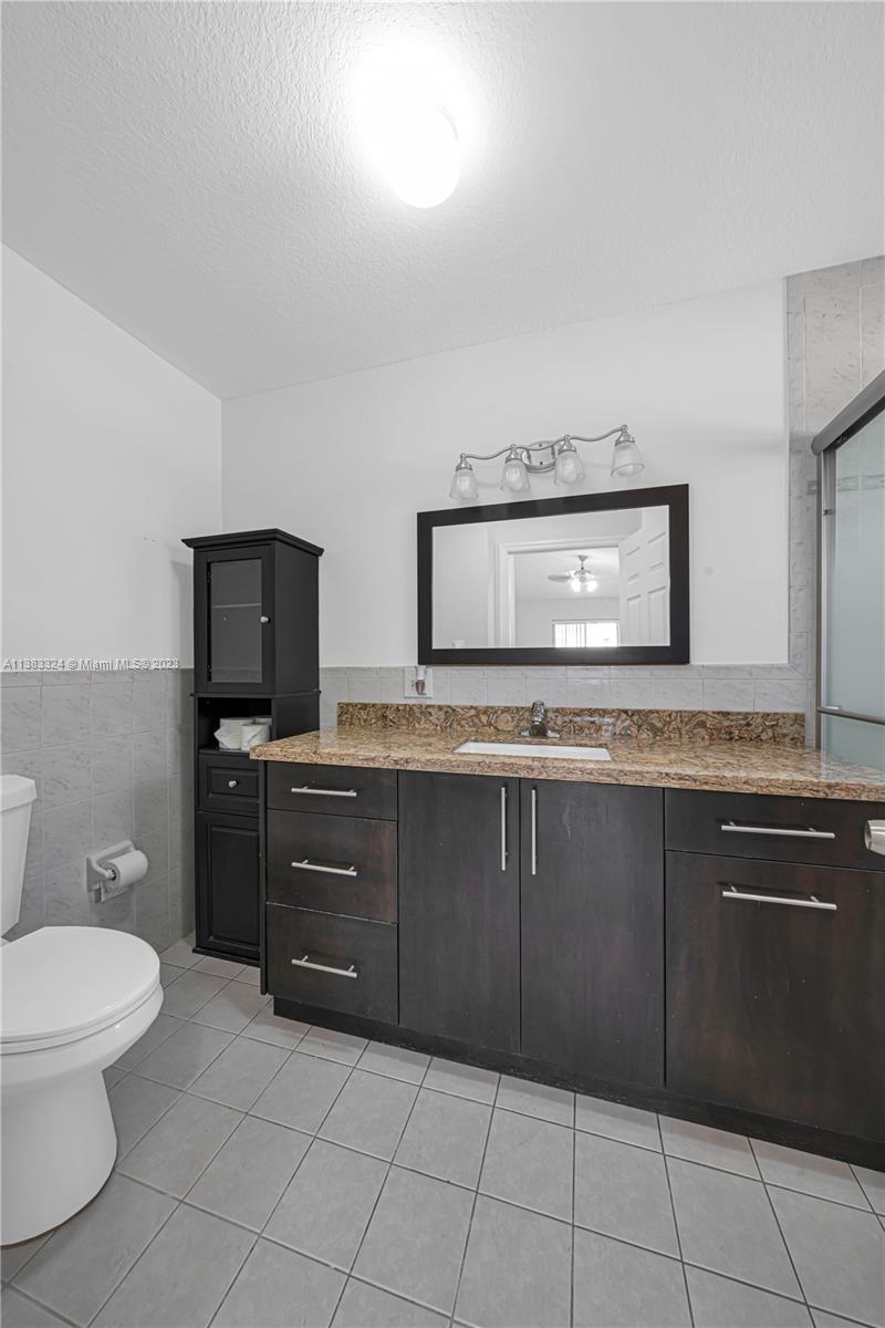 14809 Southwest 180th Street Miami, FL 33187 - Photo 31 of 38 a bathroom with a toilet a sink and mirror