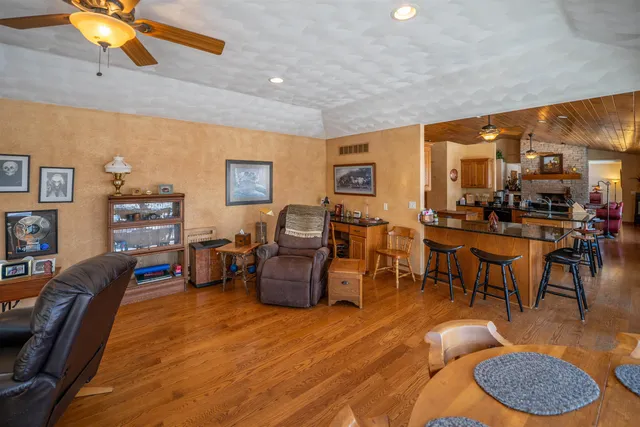 a spacious bedroom with a bed a dresser and a flat screen tv