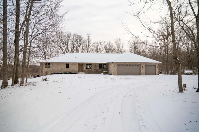 a front view of a house with a yard covered in snow