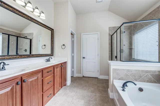 a spacious bathroom with a double vanity sink a mirror and a bathtub