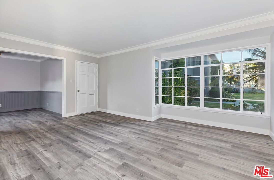 5022 Clinton Street, Unit 5022B Los Angeles, CA 90004 - Photo 3 of 22 a view of an empty room with wooden floor and a window