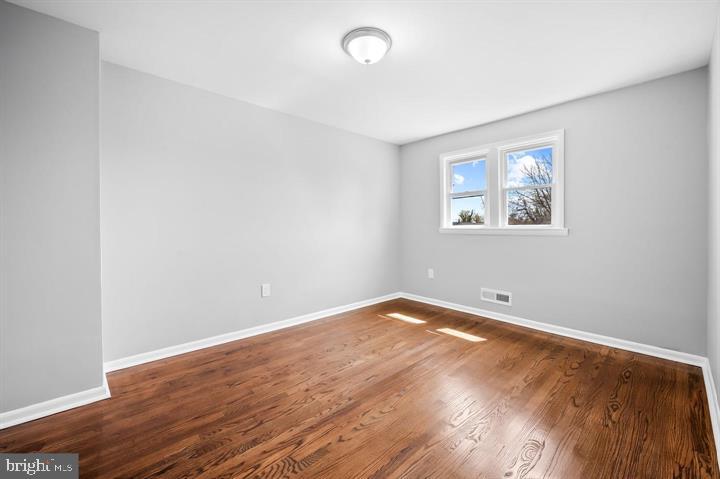 631 Charraway Road Baltimore, MD 21229 - Photo 12 of 25 an empty room with wooden floor and windows