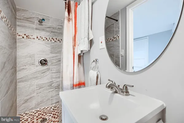 a bathroom with a sink a mirror and shower