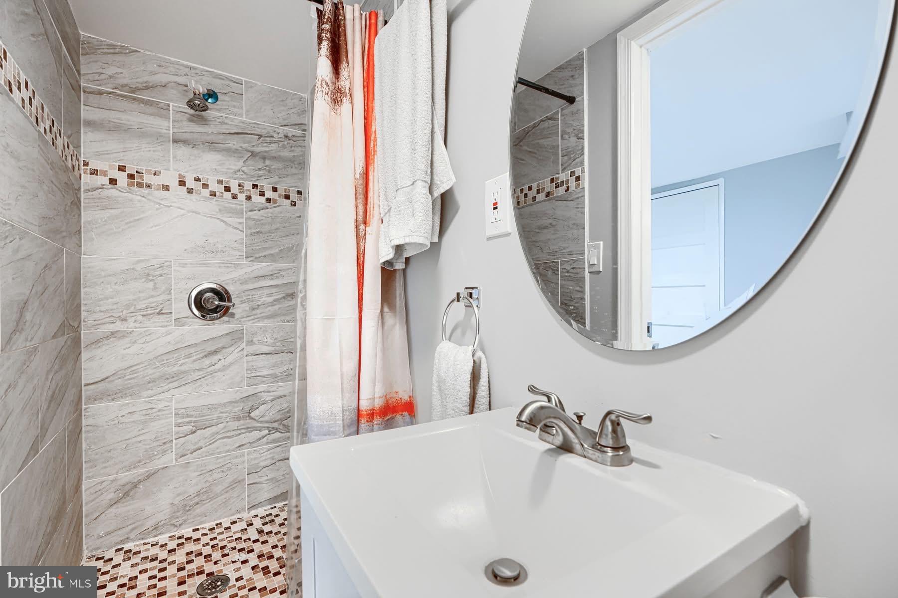 631 Charraway Road Baltimore, MD 21229 - Photo 21 of 25 a bathroom with a sink a mirror and shower