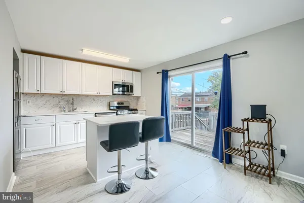 a kitchen with granite countertop a stove a sink cabinets and a dining table