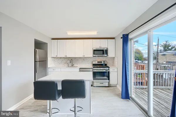 a kitchen with stainless steel appliances a stove top oven a sink and white cabinets