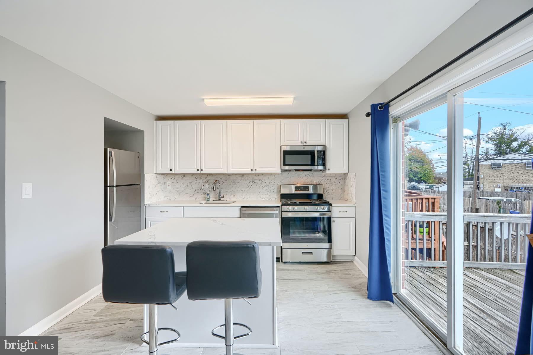 631 Charraway Road Baltimore, MD 21229 - Photo 7 of 25 a kitchen with stainless steel appliances a stove top oven a sink and white cabinets