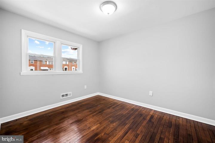 631 Charraway Road Baltimore, MD 21229 - Photo 9 of 25 an empty room with wooden floor and windows