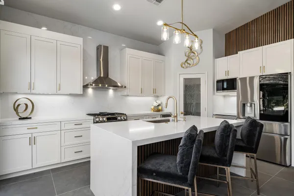 a kitchen with stainless steel appliances granite countertop a sink a stove and a refrigerator