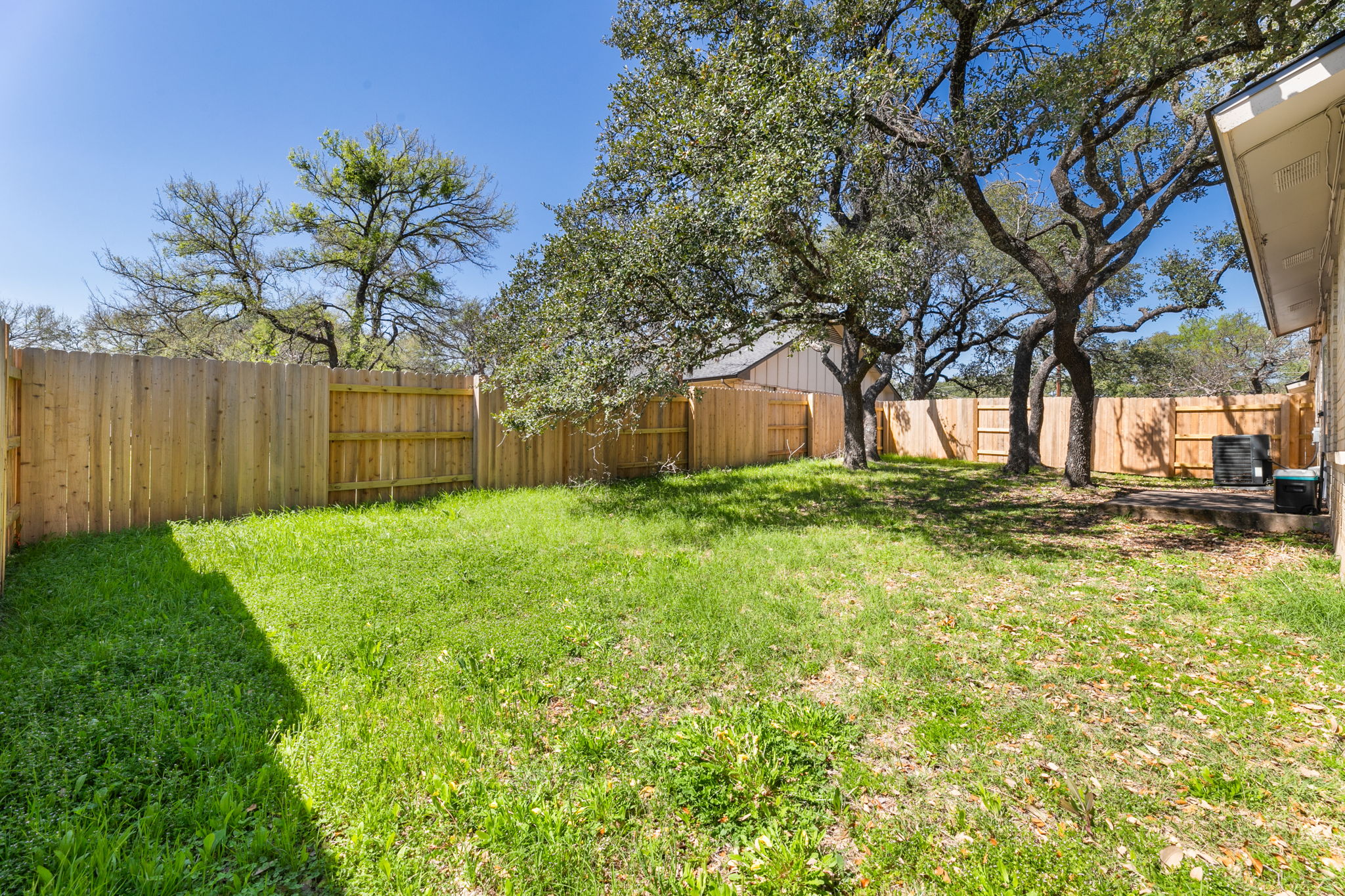 3802 Foust Trail, Unit A Georgetown, TX 78628 - Photo 31 of 34 A verdant lawn framed by mature trees, providing a private outdoor retreat.