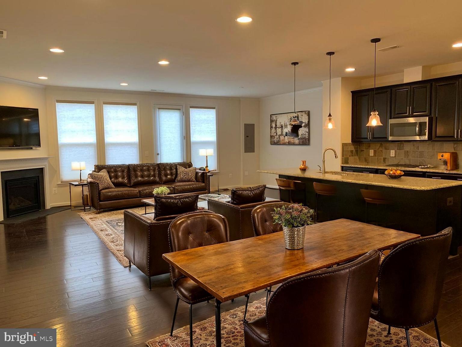 42482 Benfold Square Ashburn, VA 20148 - Photo 12 of 34 a kitchen with stainless steel appliances granite countertop a sink a stove a dining table and chairs