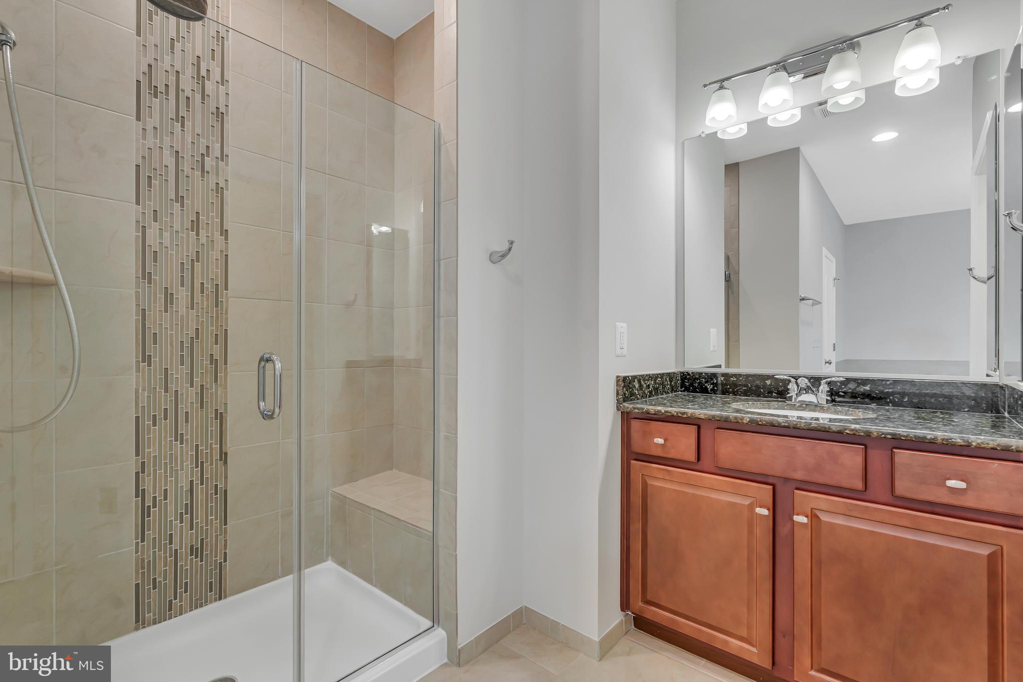 42482 Benfold Square Ashburn, VA 20148 - Photo 15 of 34 a bathroom with a granite countertop sink a toilet and shower