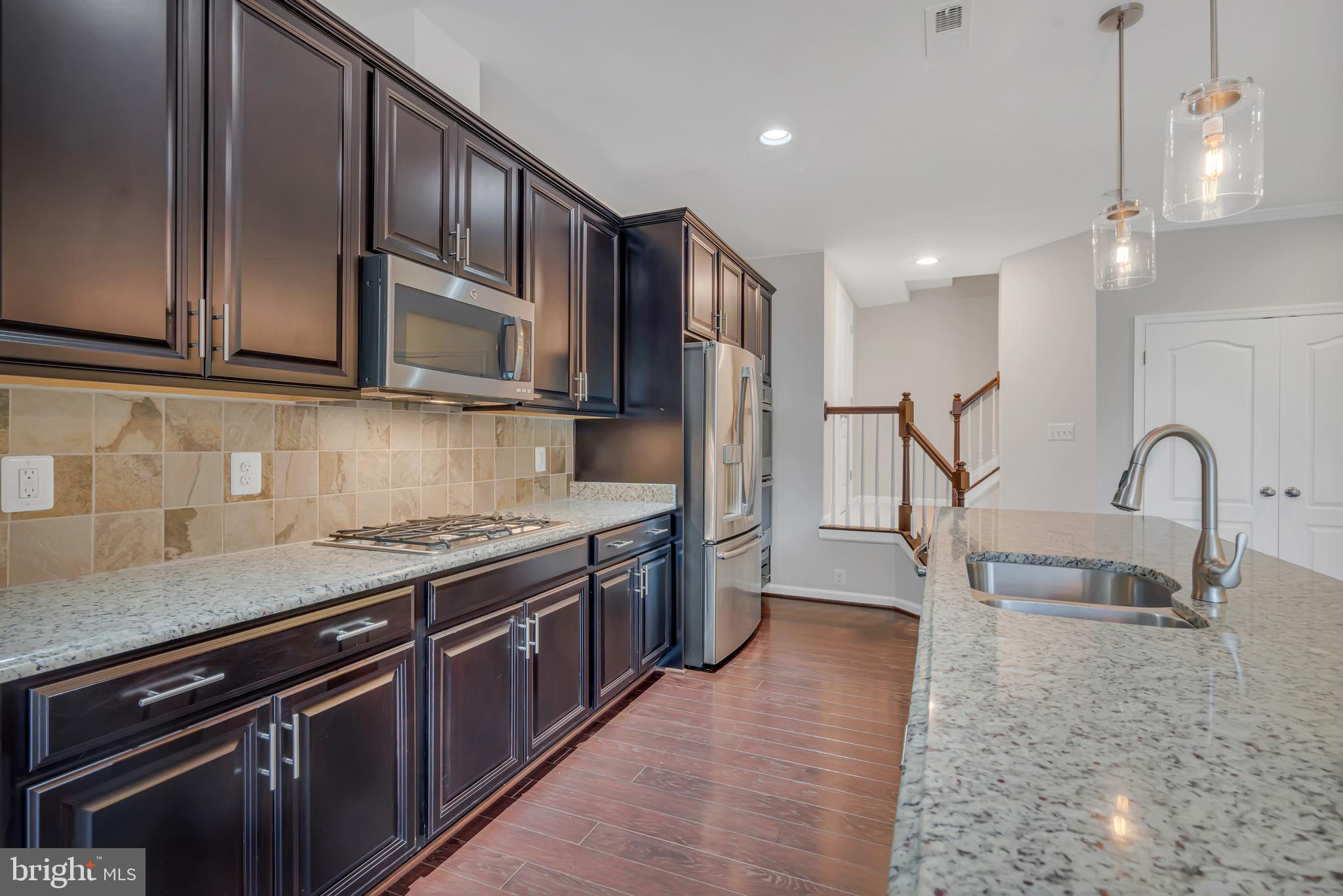 42482 Benfold Square Ashburn, VA 20148 - Photo 2 of 34 a kitchen with stainless steel appliances granite countertop a stove a sink and a microwave