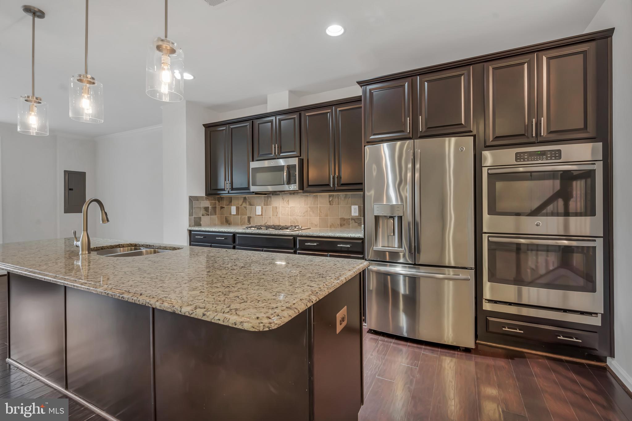 42482 Benfold Square Ashburn, VA 20148 - Photo 4 of 34 a kitchen with kitchen island a counter top a refrigerator and a sink