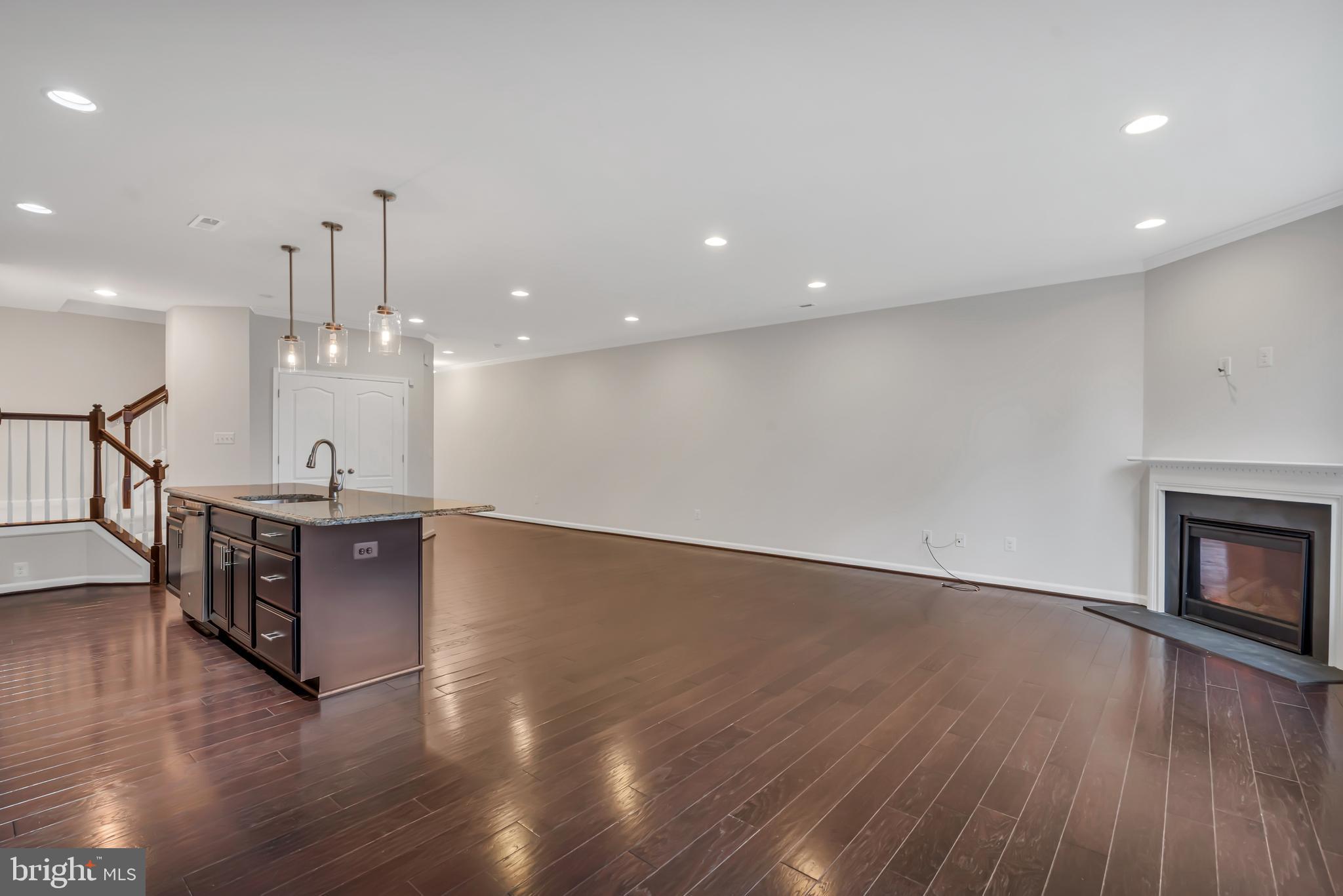 42482 Benfold Square Ashburn, VA 20148 - Photo 9 of 34 an open kitchen with wooden floor and a fireplace