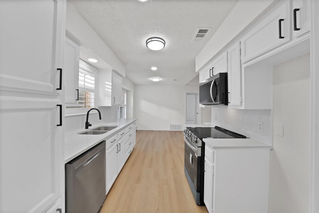 825 Meadowdale Road Arlington, TX 76017 - Photo 4 of 19 a kitchen with stainless steel appliances granite countertop a sink and stove top oven