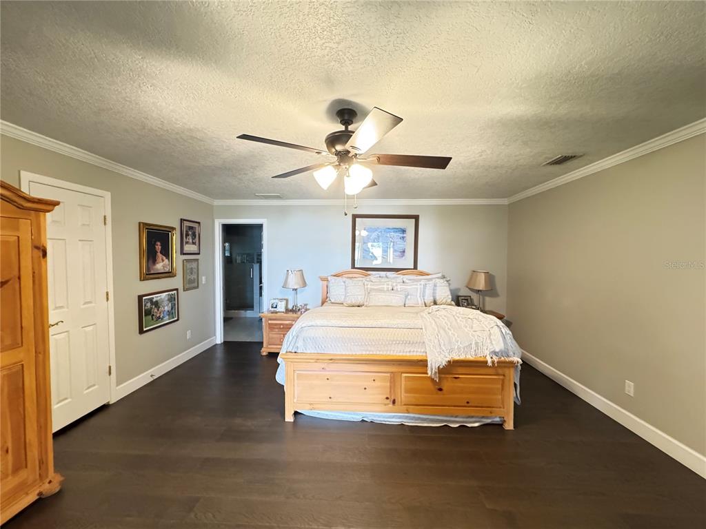 334 West F Street Frostproof, FL 33843 - Photo 26 of 48 a spacious bedroom with a bed and a chandelier