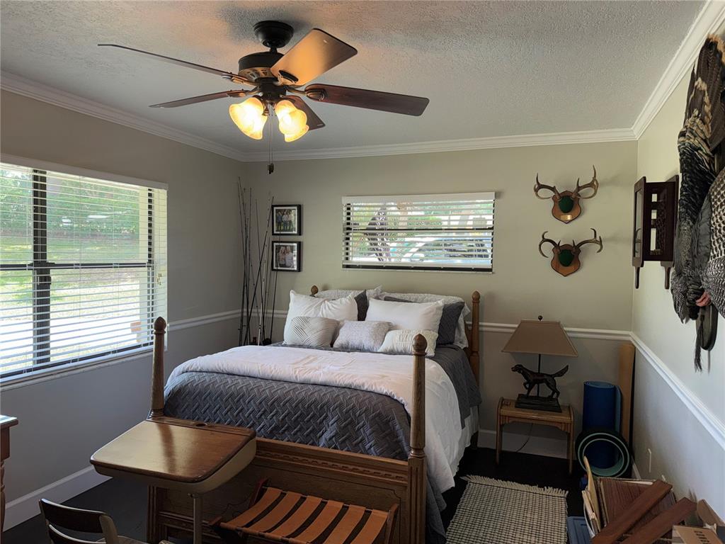 334 West F Street Frostproof, FL 33843 - Photo 8 of 48 a bedroom with a bed and a chandelier