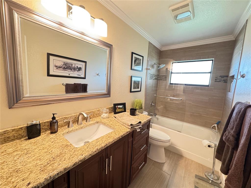 334 West F Street Frostproof, FL 33843 - Photo 10 of 48 a bathroom with a granite countertop sink mirror vanity and toilet
