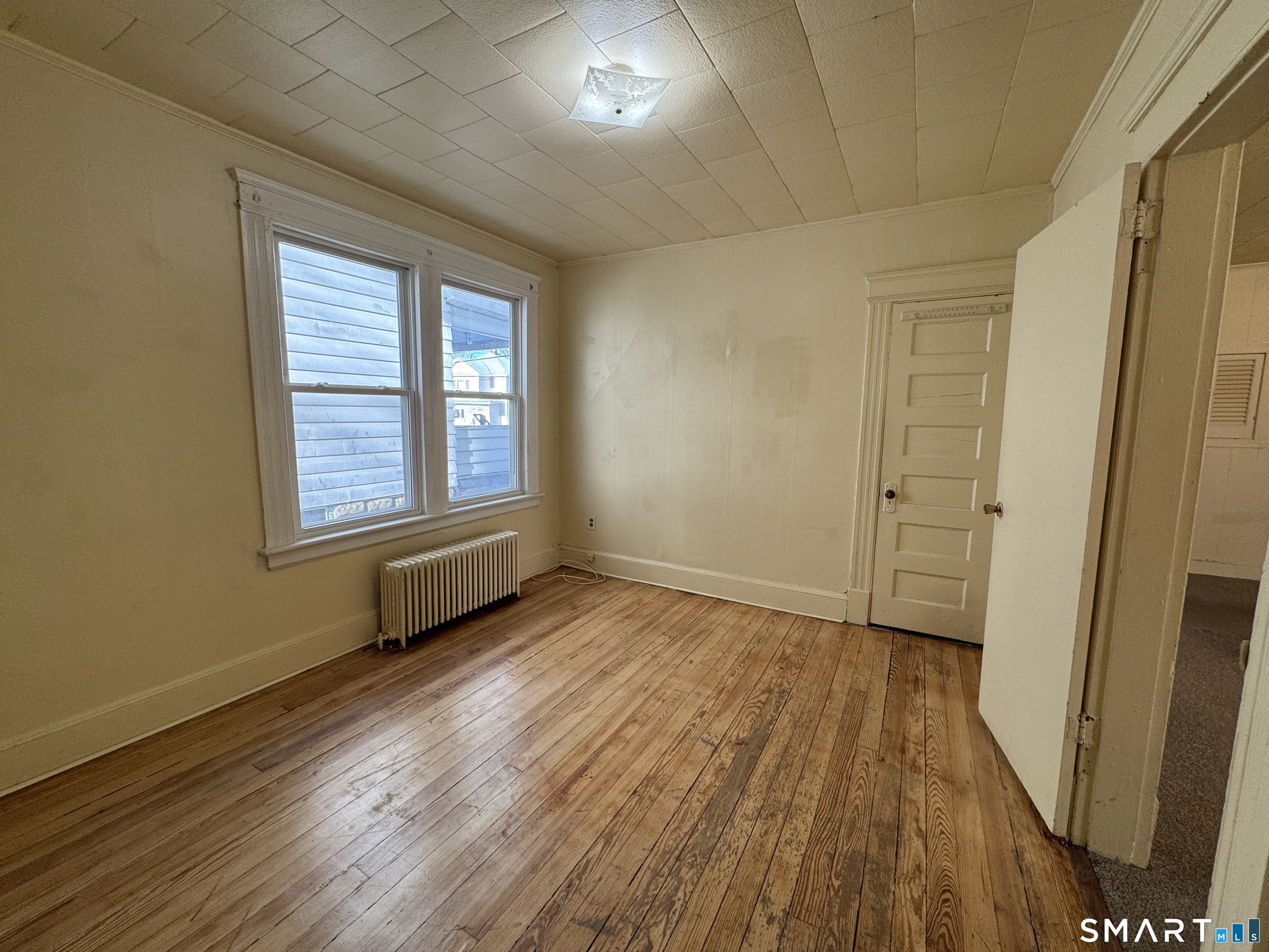 1720 East Main Street, Unit 1 Waterbury, CT 06705 - Photo 8 of 9 a view of an empty room with wooden floor and a window